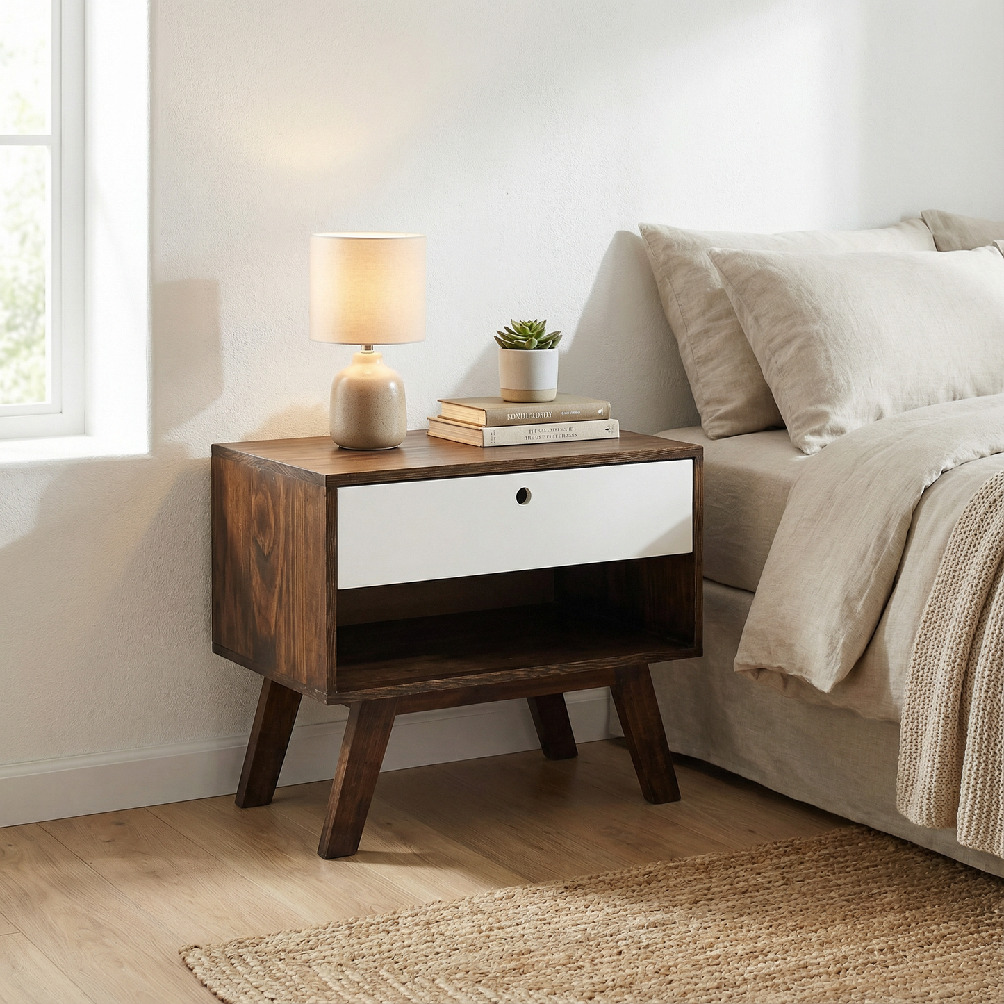 Buró de madera estilo moderno con un cajón, adaptado a una recámara junto a una cama, dando estilo.