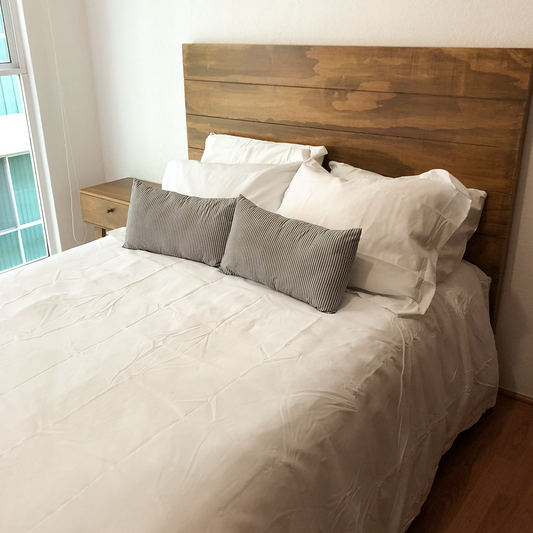 Cama flotante, madera de color obscuro con colchón blanco y fondo blanco.