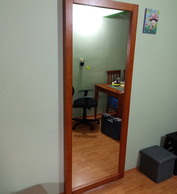 Espejo con marco de maderal con vista lateral viendo su funcionalidad.