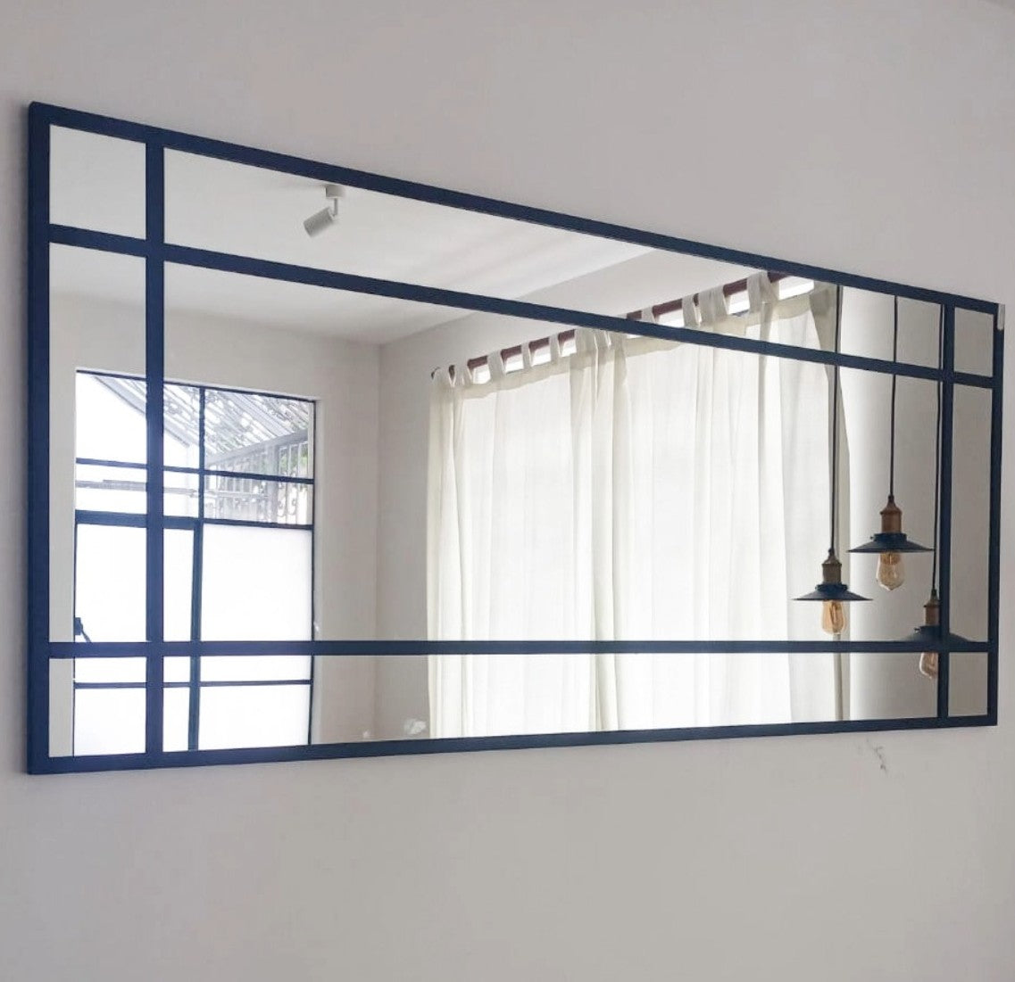 Espejo rectangular con vista lateral.