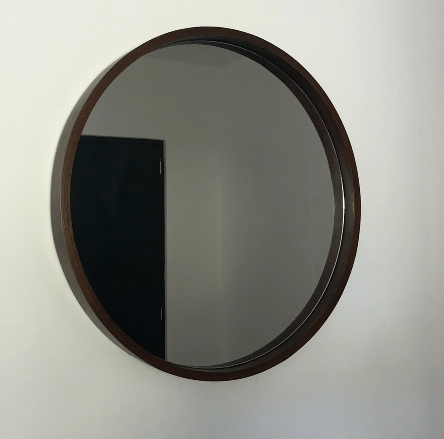 Espejo redondo con marco de madera con vista lateral.