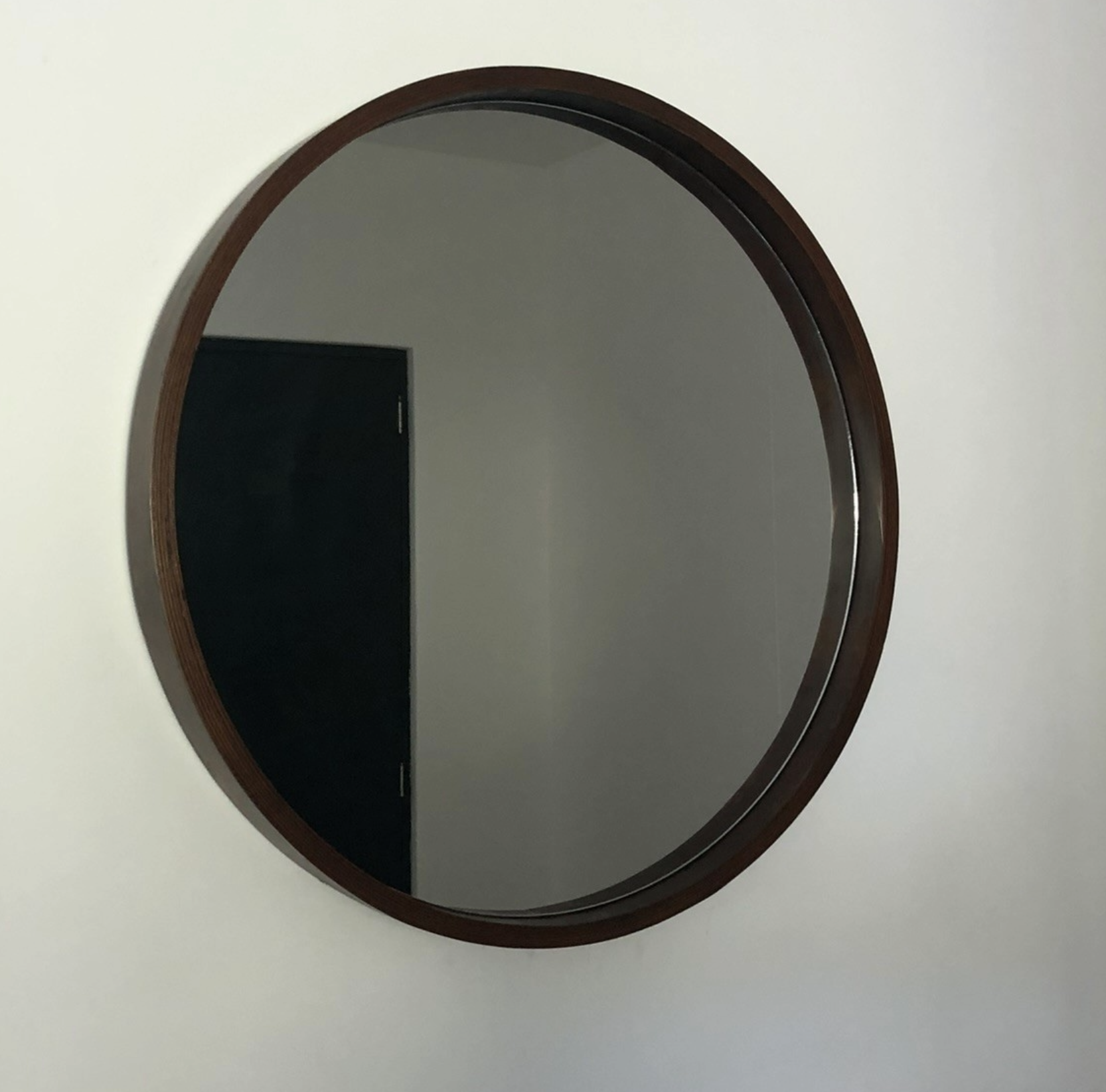 Espejo redondo con marco de madera con vista lateral.