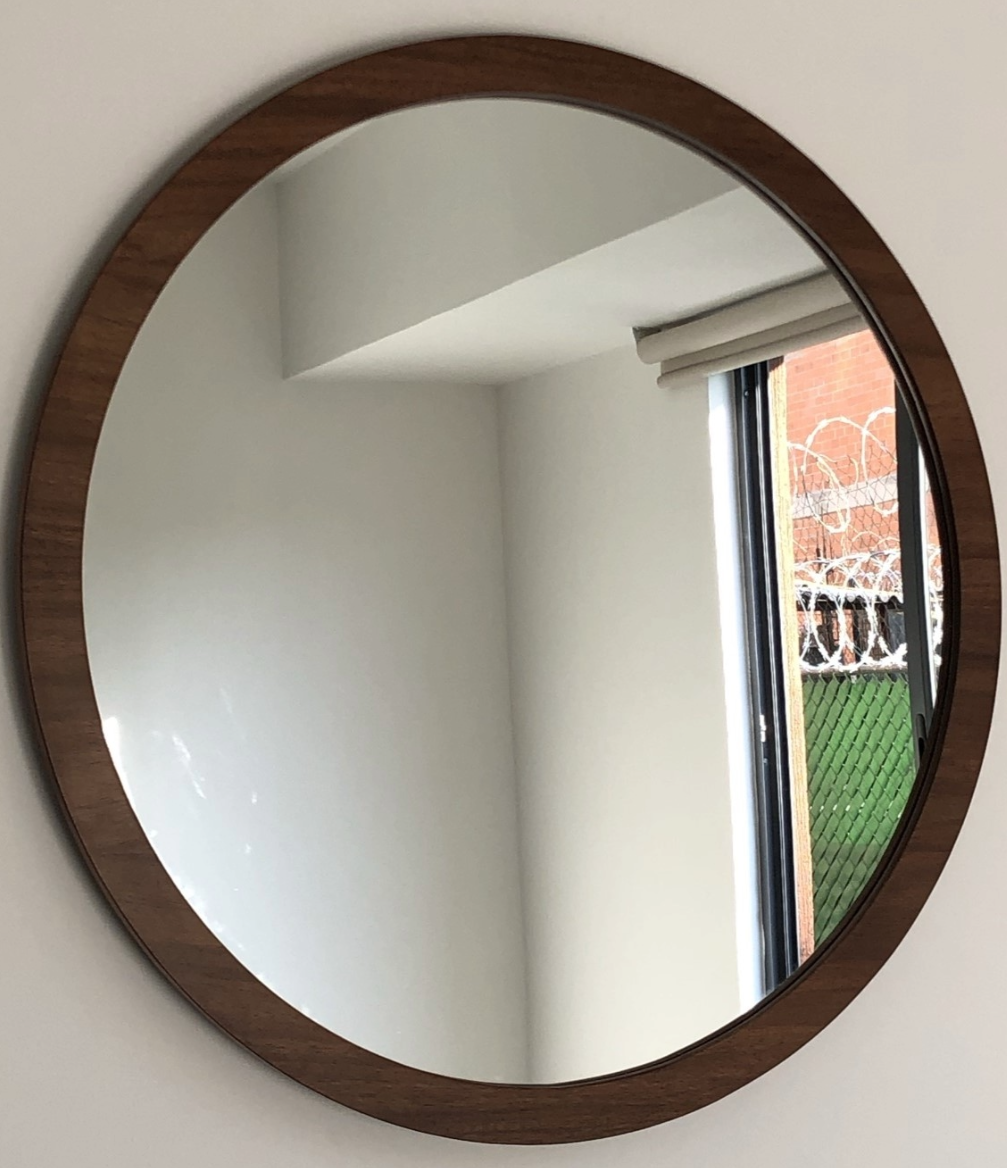 Espejo redondo con marco de madera.