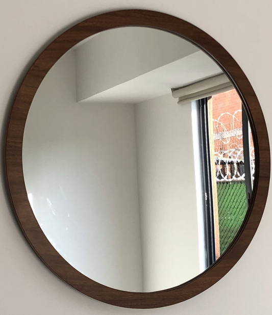 Espejo redondo con marco de madera.