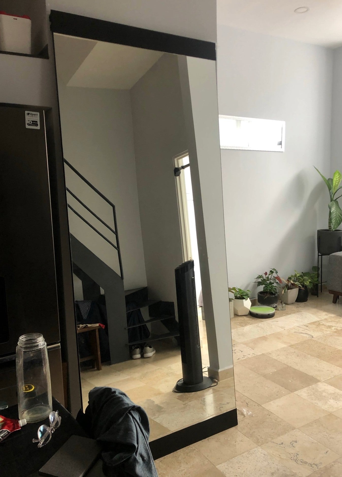 Espejo gigante con bases en la parte lateral y superior del espejo.