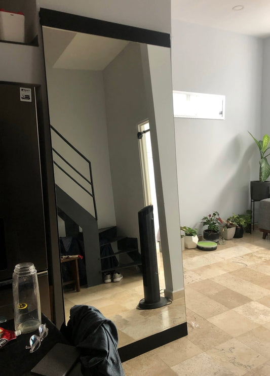 Espejo gigante con bases en la parte lateral y superior del espejo.