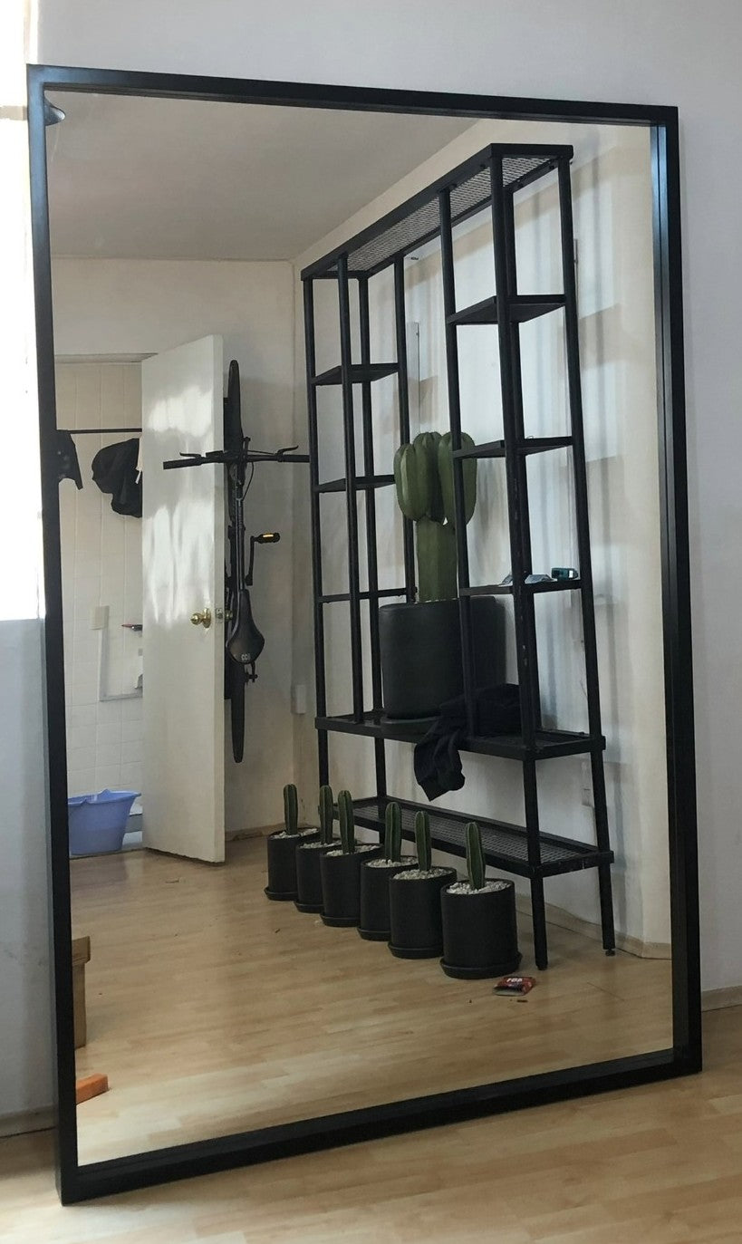 Espejo gigante con marco de madera color negro.