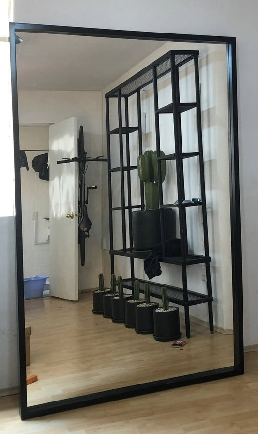 Espejo gigante con marco de madera color negro.