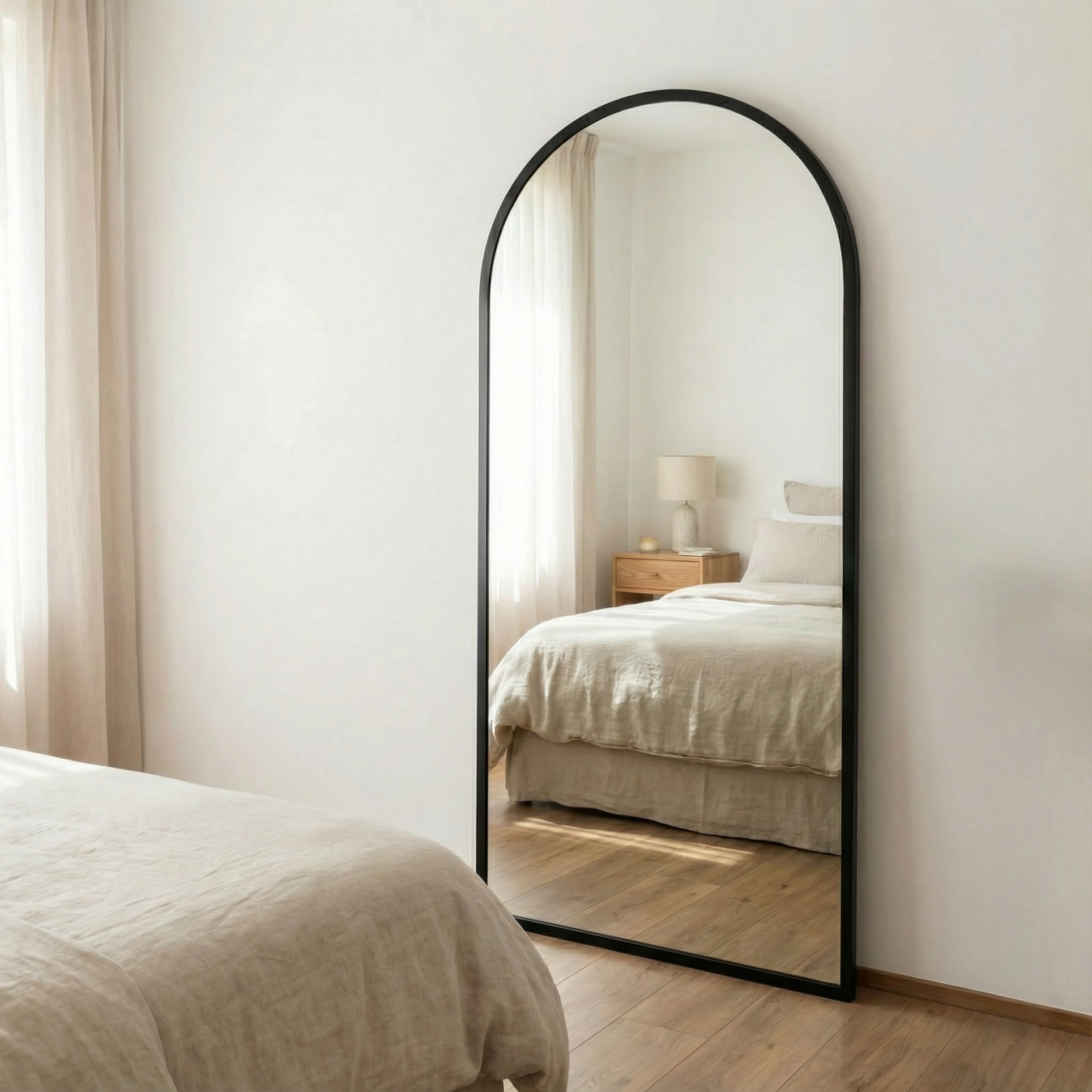  Espejo Moliere con marco de herrería, frente a una cama con luz natural.