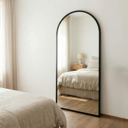  Espejo Moliere con marco de herrería, frente a una cama con luz natural.