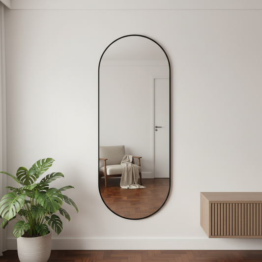Espejo ovalado con marco negro ubicado en una habitación.