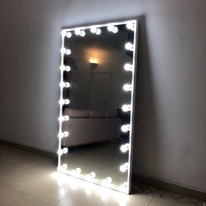 Espejo hollywood; Espejo de gran tamaño recargado sobre una pared, la orilla del espejo cuenta con varios focos instalados en la orilla, que se prenden y otorgan luz.
