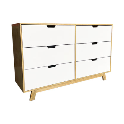 Cómoda Alcalá, vista frontal lateral del mueble mostrando a detalles los cajones en color blanco y acabados en madera natural.