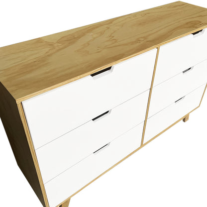Cómoda Alcalá, vista a detalle de la parte lateral del mueble, mostrando los cajones en un color blanco y acabados en madera natural.